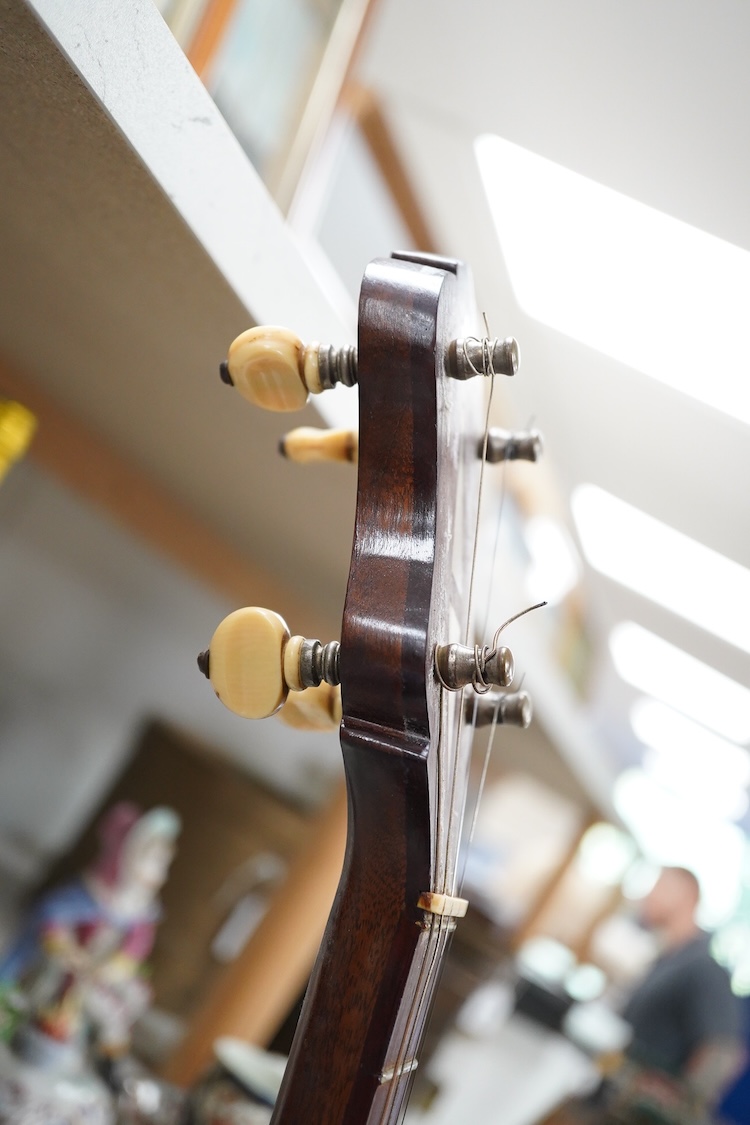 A cased Vega 4-string tenor banjo stamped M. Roccia, steel body with veneered back, the case embossed with; Ronald Quilter, 10, Cadogan Lane, London S.W.1., overall length 82cm